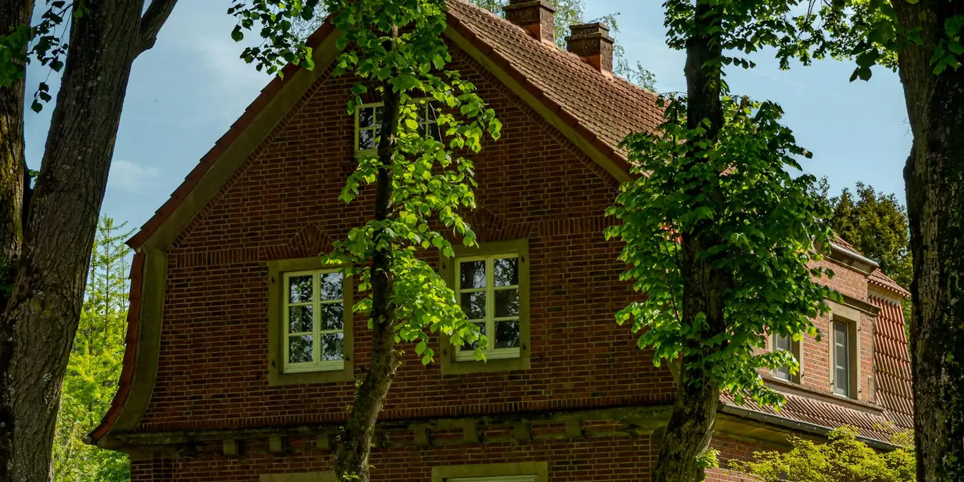Maison en briques sous de vieux arbres